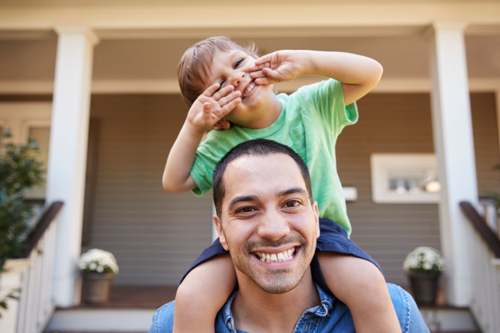 father with son on shoulders at home