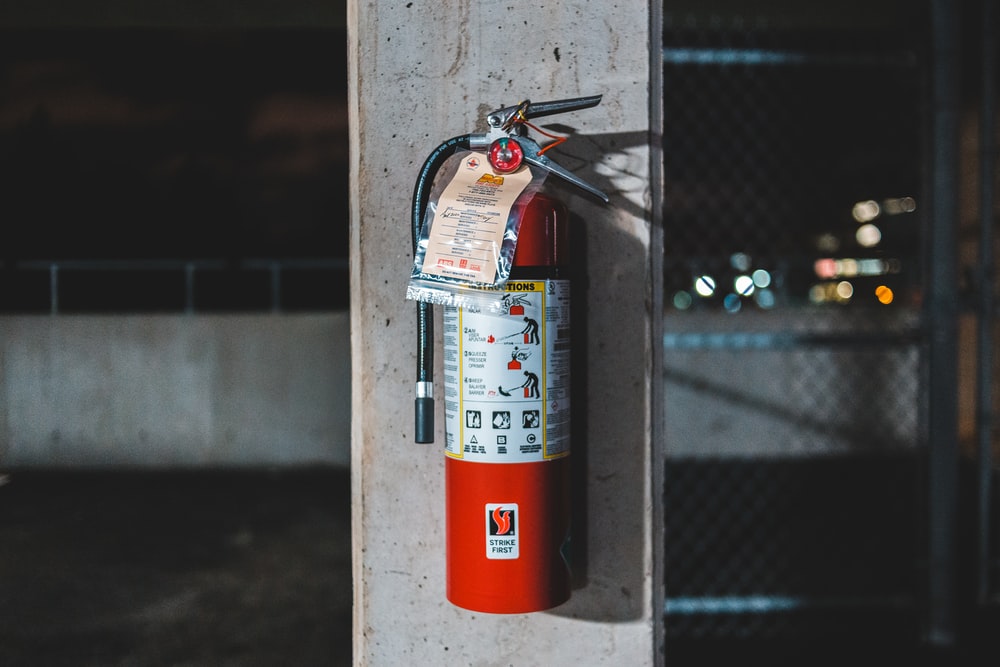 red fire extinguisher mounted on pillar